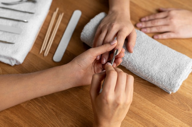 Close up manicurist using nail tool