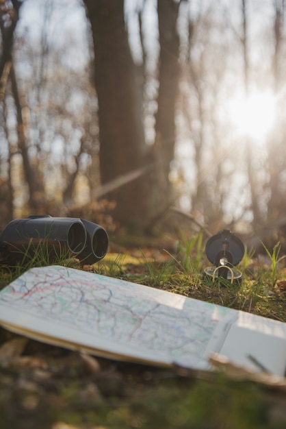 Free Photo close-up of map, binoculars and compass on the grass