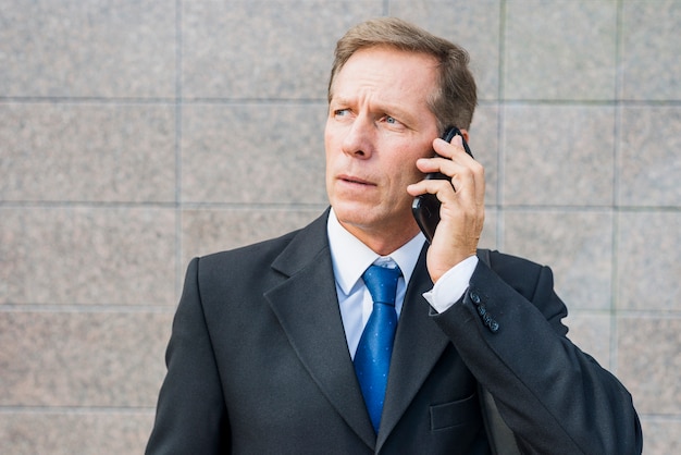 Close-up of a mature businessman talking on smartphone