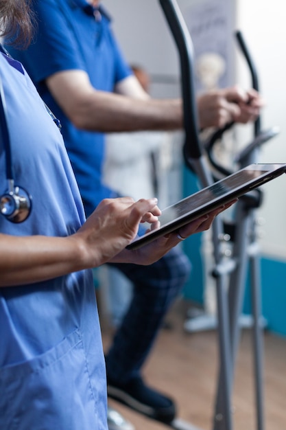 Close up of medical assistant touching tablet display