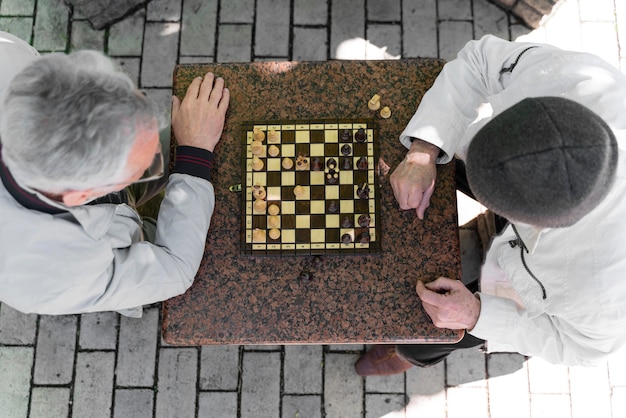 Free Photo close up men playing chess together top view