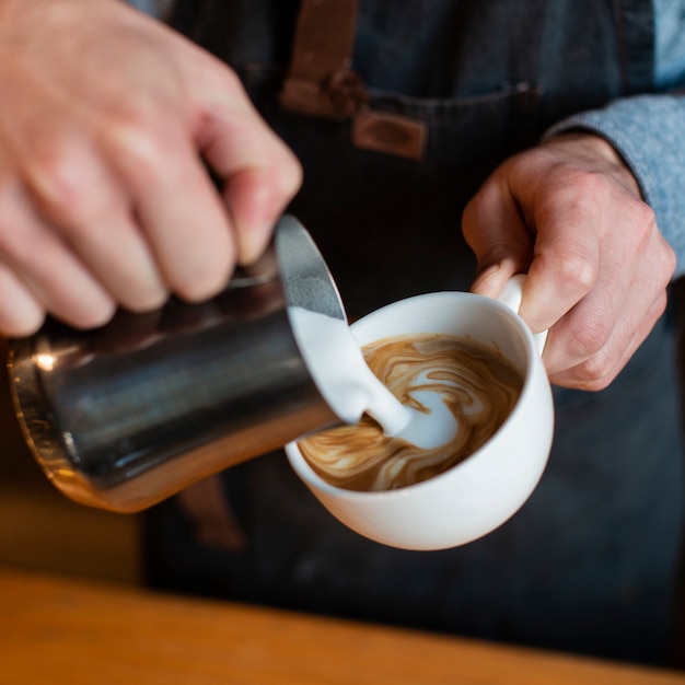 Close-up of milk poured in coffee cup