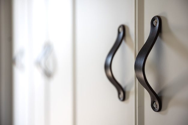 Free Photo close up of minimalistic white furniture with black handles, kitchen cabinet, details.