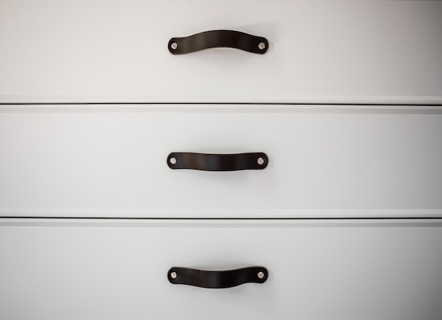 Free Photo close up of minimalistic white furniture with black handles, kitchen cabinet, details.