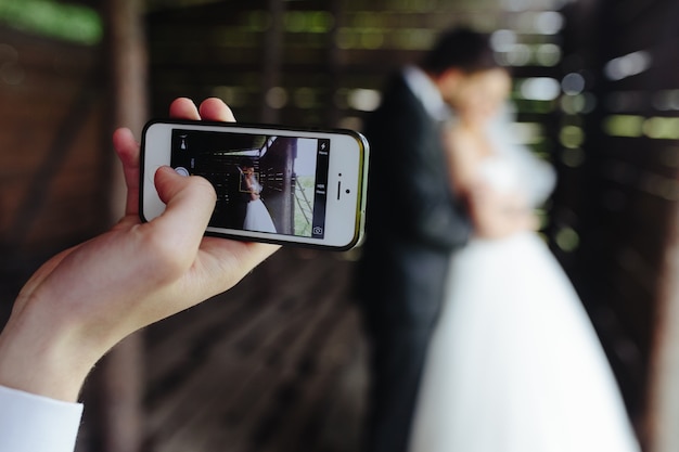 Close-up of mobile taking a photo of the newlyweds