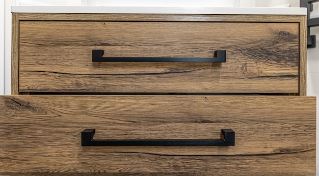 Free Photo close-up of modern dark wood furniture with black handles.