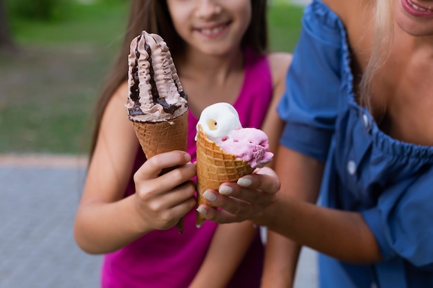 Close-up of mom and daughter holding ice cream