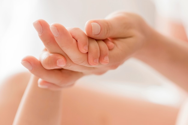 Close-up mom holding baby's hand