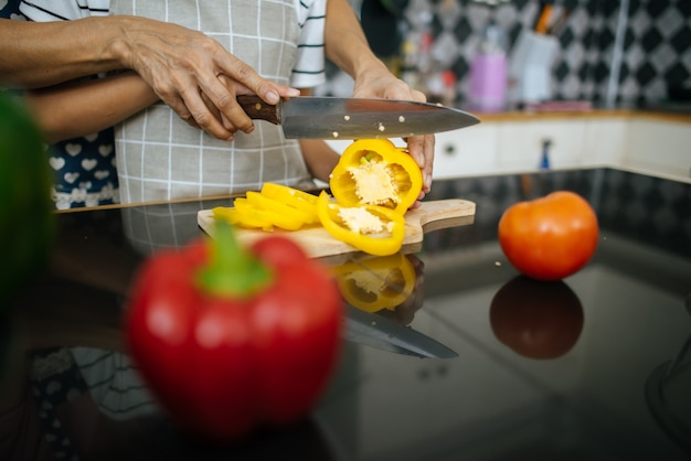 Free photo close up of mom’s hand teaching her daughter preparing and chopping vegetable.