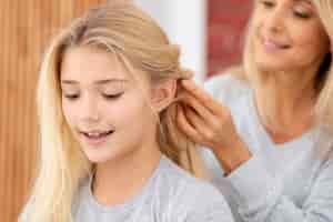 Free photo close-up mother braiding daughter hair