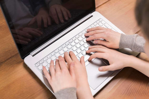 Free photo close-up mother teaching son how to use laptop