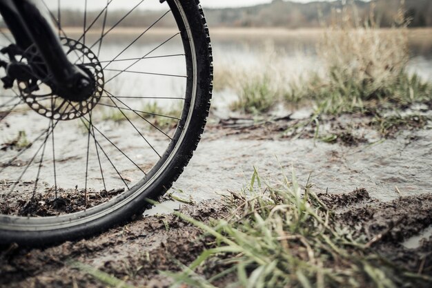 Close-up of mountain bike wheel in the mud near the lake