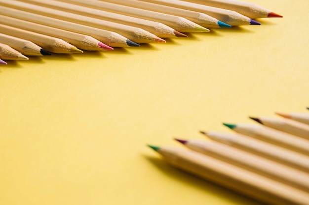 Close-up of multi colored pencils on yellow background