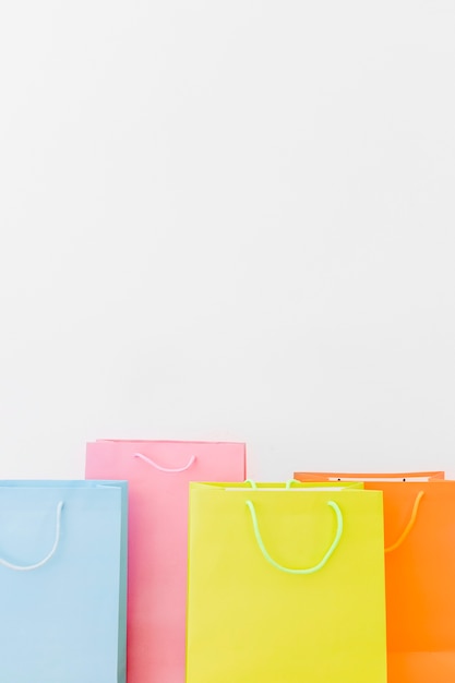 Free Photo close-up of multi colored shopping bags on white background