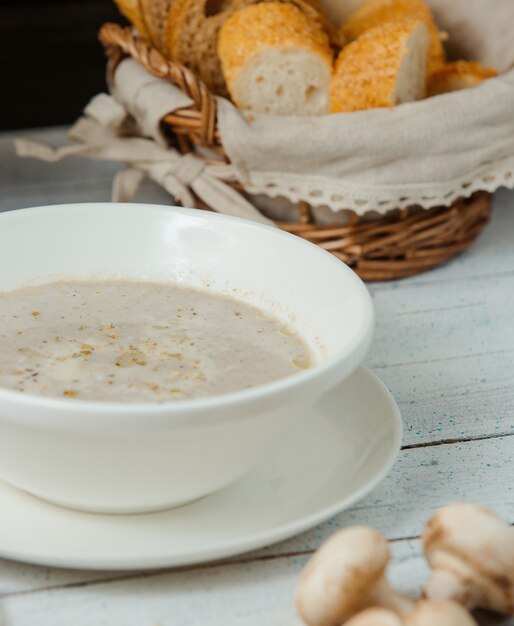 close up of mushroom soup in bowl served with bread