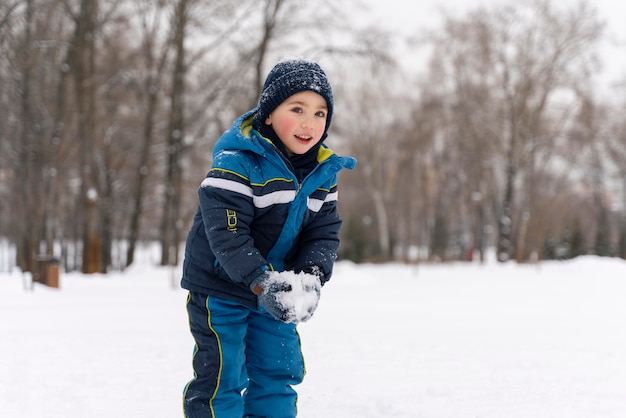 Close up n happy kid playing in the snow