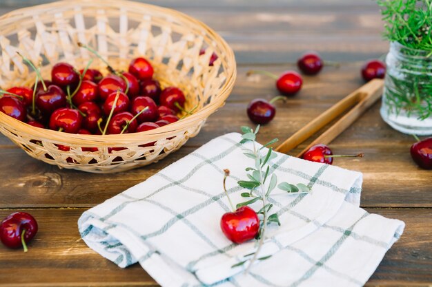 Close-up of napkin and juicy red cherries in wicker bowl