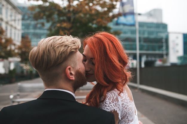 Free photo close-up of newlyweds kissing with city background