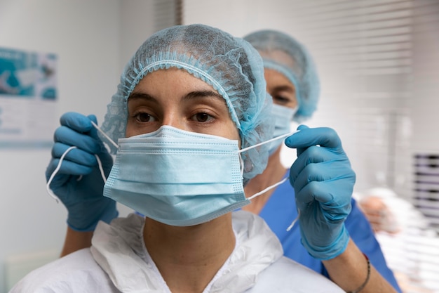 Close up nurse putting on face mask