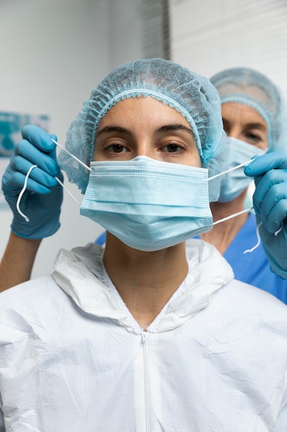 Close up nurse putting on mask