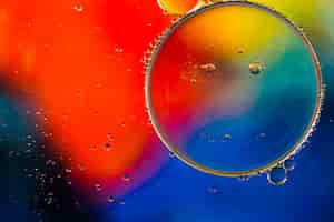 Free photo close-up oily bubbles and droplets in colourful watery backdrop