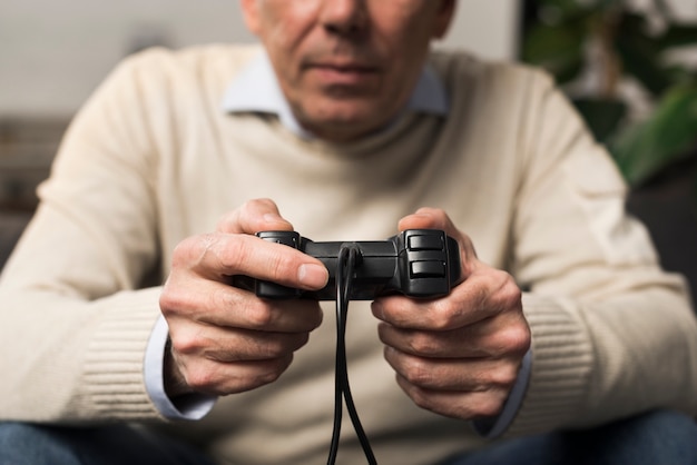 Free photo close-up old man holding controller