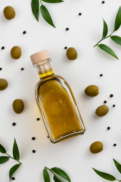 Free photo close-up olive oil bottle with leaves next