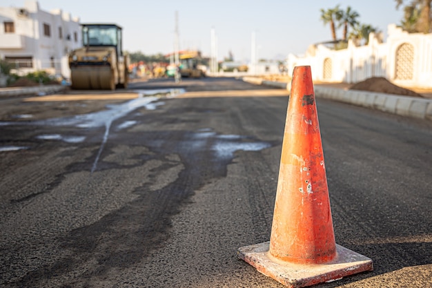 Free photo close up of an orange traffic cone on the road copy space