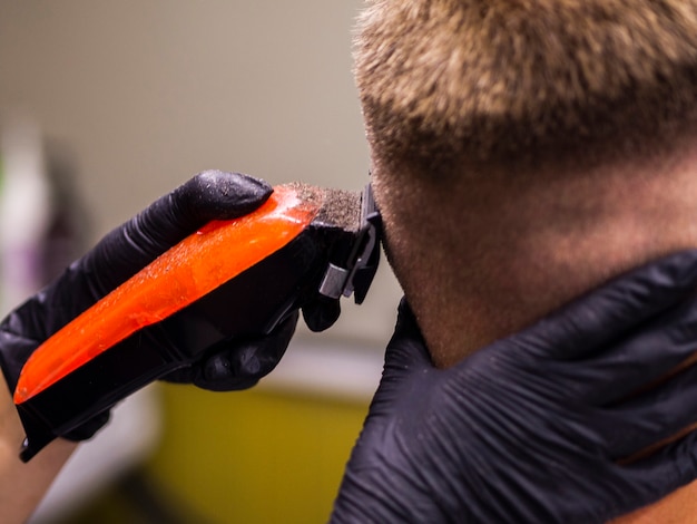 Free photo close-up of orange trimmer and black gloves