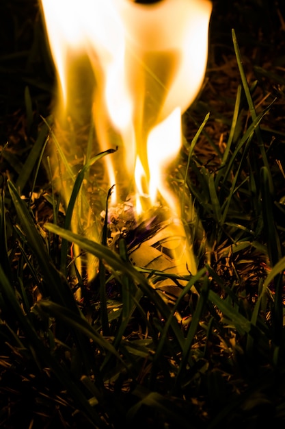 Free photo close up of a paper airplane model burning in dried grass