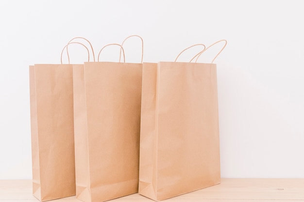 Close-up of paper shopping bags on wooden desk