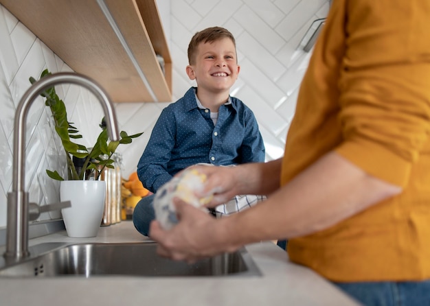 Close up parent washing dishes