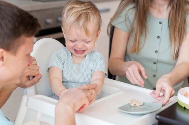 Free photo close up parents feeding toddler