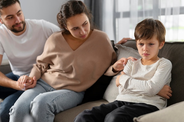 Close up parents and sad kid at therapy