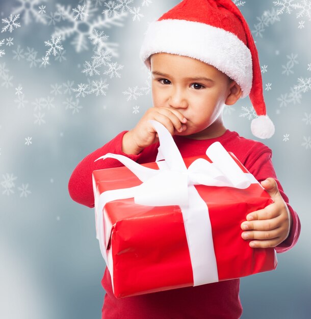 Close-up of pensive little boy with a present