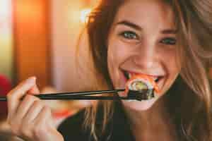 Free photo close up on people eating sushi