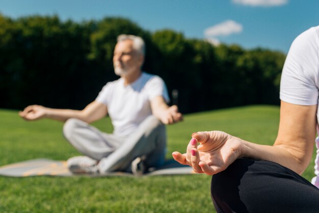 Close-up people meditating outdoors