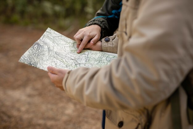 Close-up people reading a map outdoors