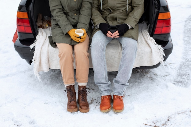 Close up people sitting on car trunk