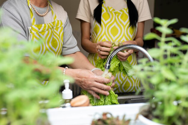 Close up people washing lettuce