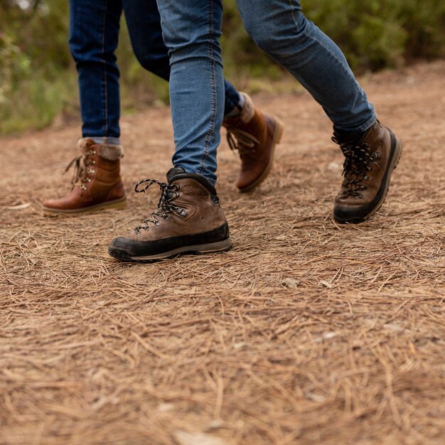 Close-up people with boots walking