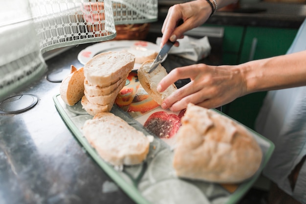 Free photo close-up of a person applying cheese to slices of bread