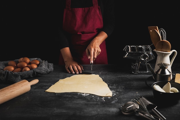 Free photo close-up person cutting dough