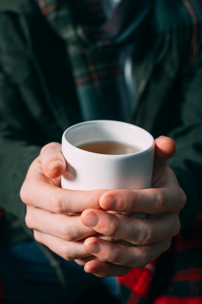 Free photo close-up person holding mug with warm drink