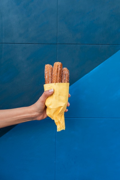 Free photo close-up person holding up food with blue background