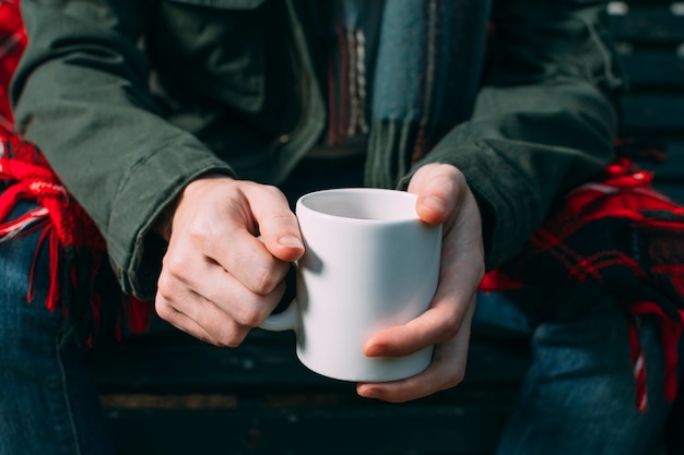 Free Photo close-up person holding up white mug