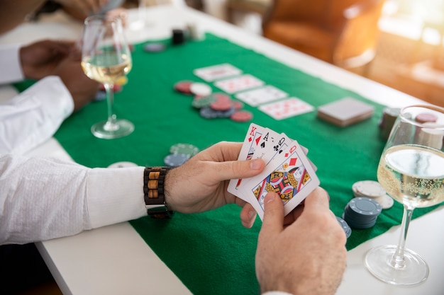 Close up on person playing poker with friends