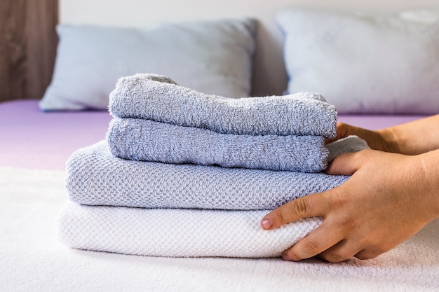 Free photo close-up person putting towels on bed