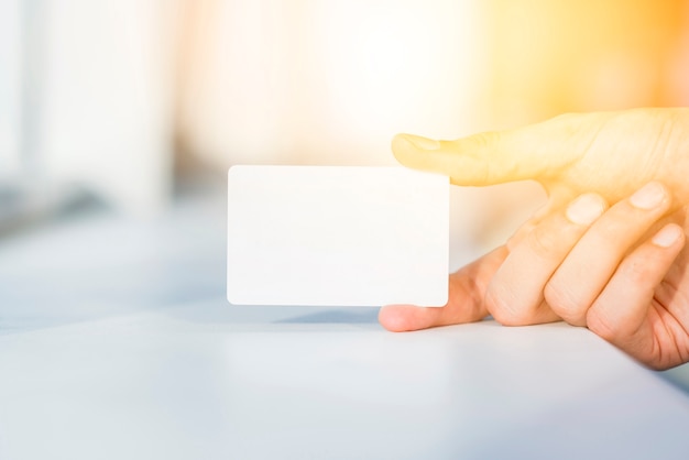 Close-up of a person's hand holding blank white card