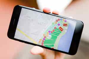 Free photo close-up of a person's hand holding smartphone with map gps navigation